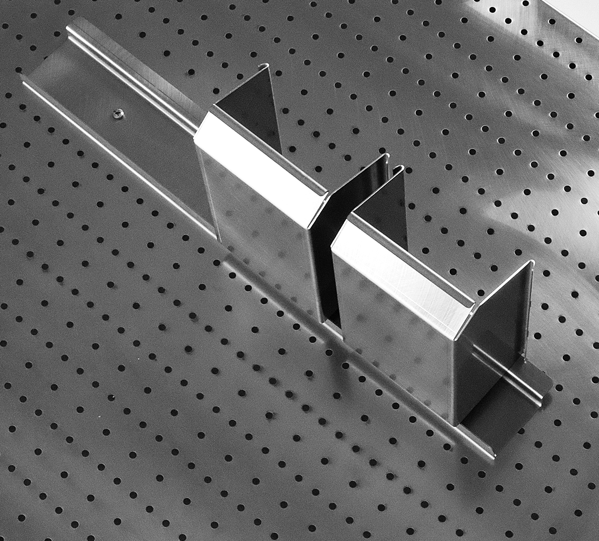 Stainless steel mounting rail for trayes for a perforated board